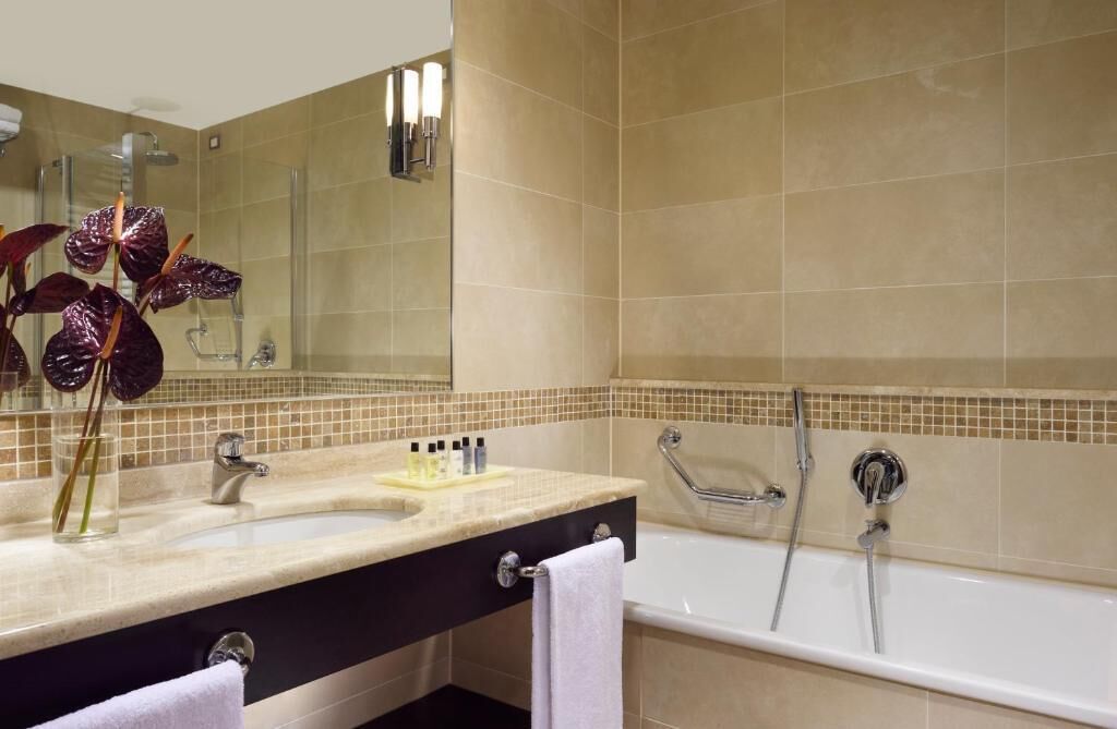 Ein Badezimmer mit Waschbecken, Spiegel und Badewanne.