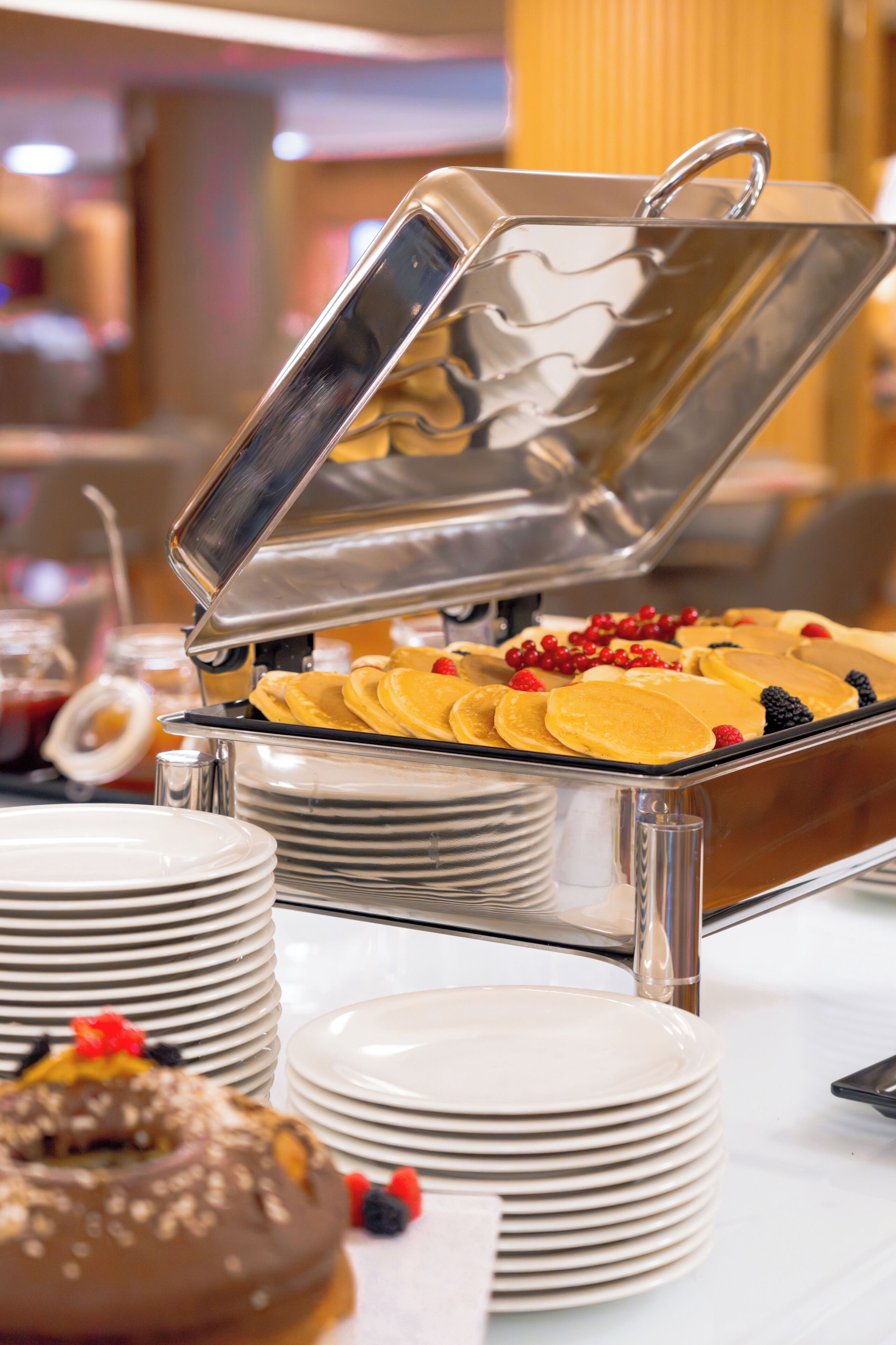 A buffet setup with various food items and a metal serving tray.