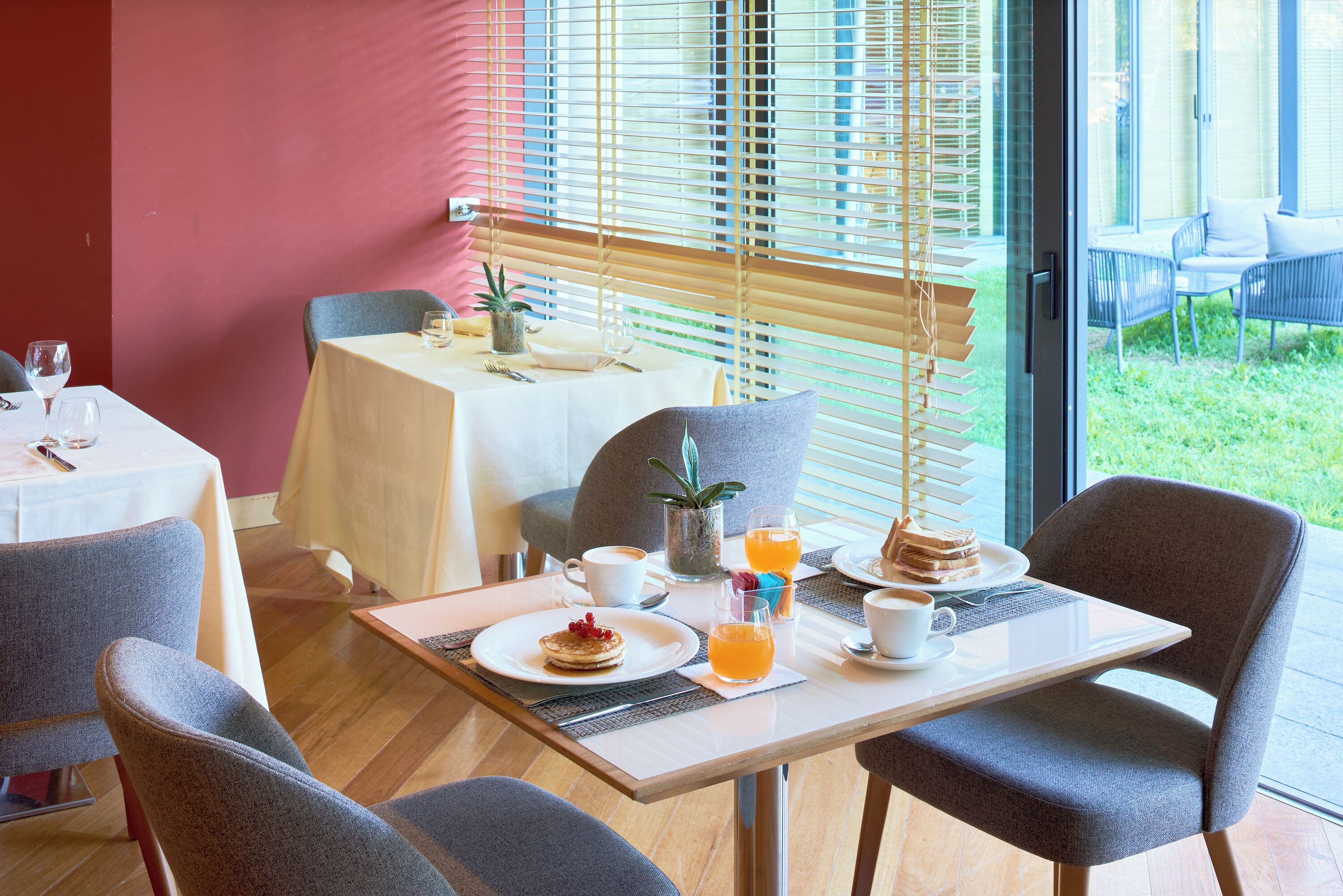 A breakfast setting with a table, chairs, and a view of the outdoors.