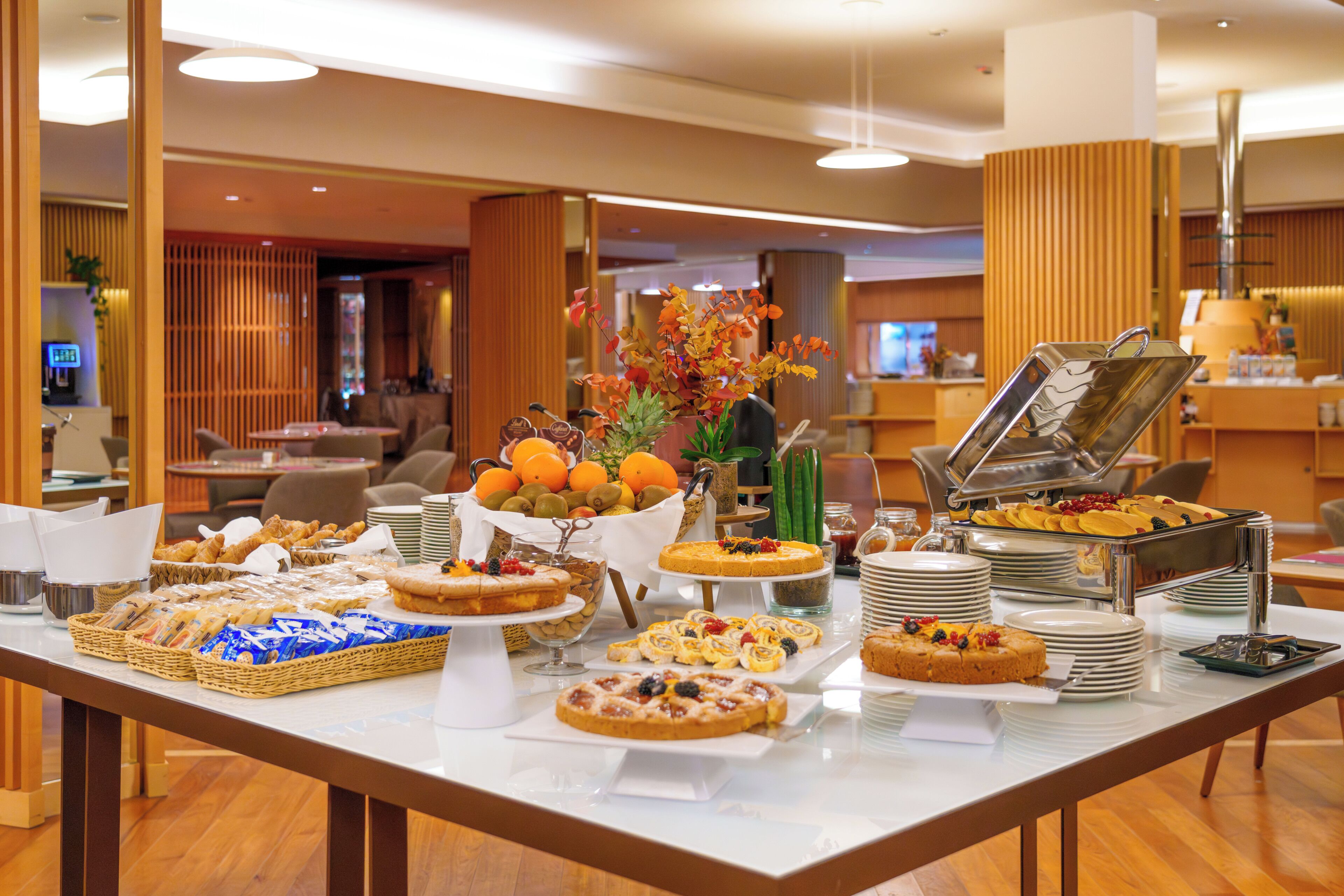 A buffet with various food items and a decorative centerpiece.