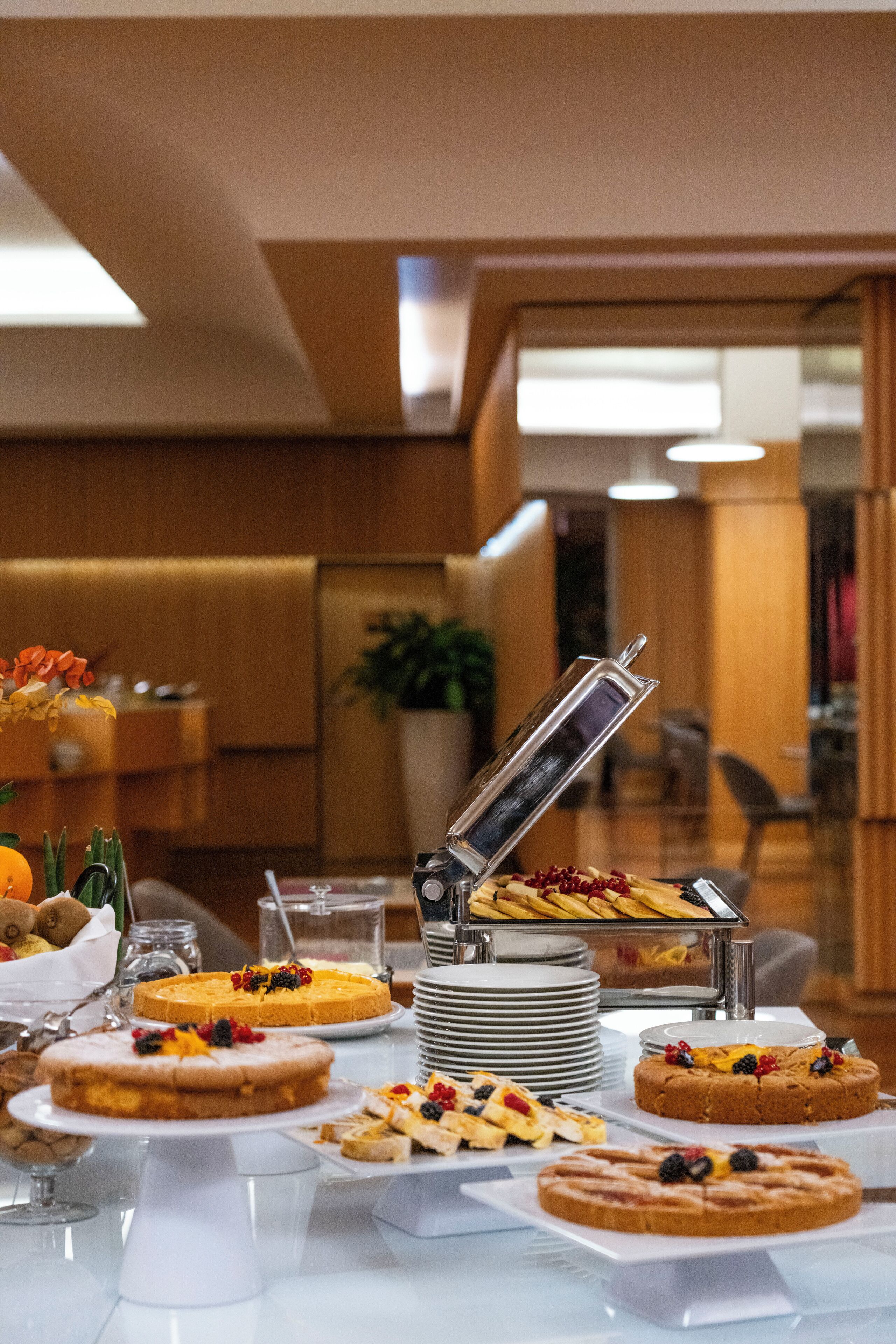 A buffet table with various desserts and a self-service beverage dispenser.