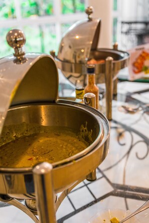 A stainless steel buffet setup with a covered bowl and a bottle of sauce. - Villa Ocean View (Wadduwa)