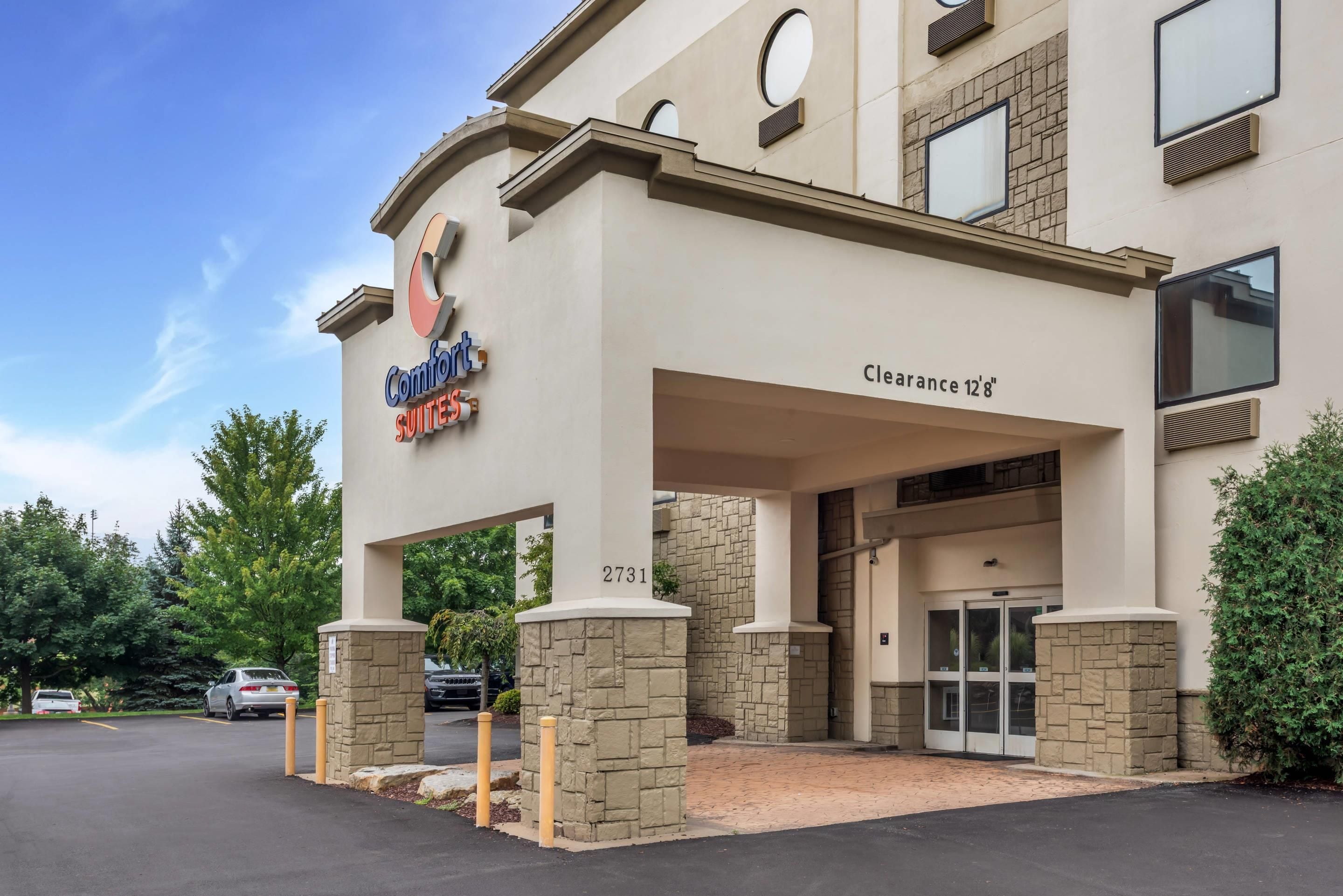 A hotel entrance with a sign indicating a clearance of 12'8'.