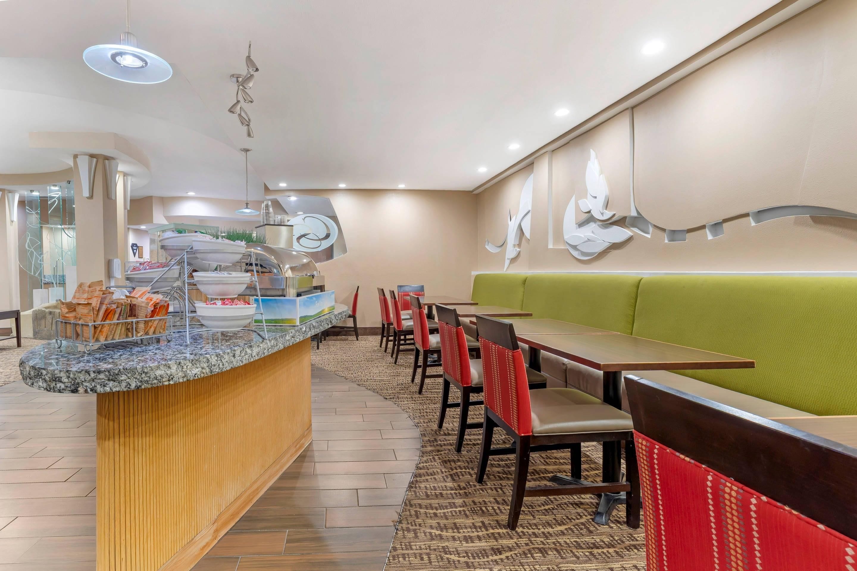 Restaurante com balcão, área de estar e decoração na parede.