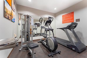 A fitness center with cardio equipment, a weight machine, and a mirrored wall. - Comfort Suites Monroeville - Pittsburgh East (Monroeville)