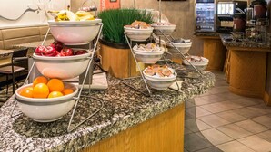 Montaje de bufé con diversas opciones de comida y una estación de café.