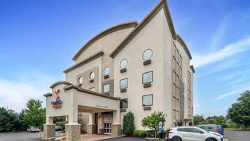 A hotel with a curved facade, multiple windows, and a clear sky.