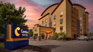 Un hotel Comfort Suites con entrada despejada, aparcamiento y cartel.
