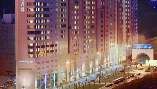 A multi-story hotel with a prominent 'MERIDEN' sign, featuring a modern architectural design with a series of balconies and a well-lit facade. - Le Meridien Towers Makkah (Makkah)