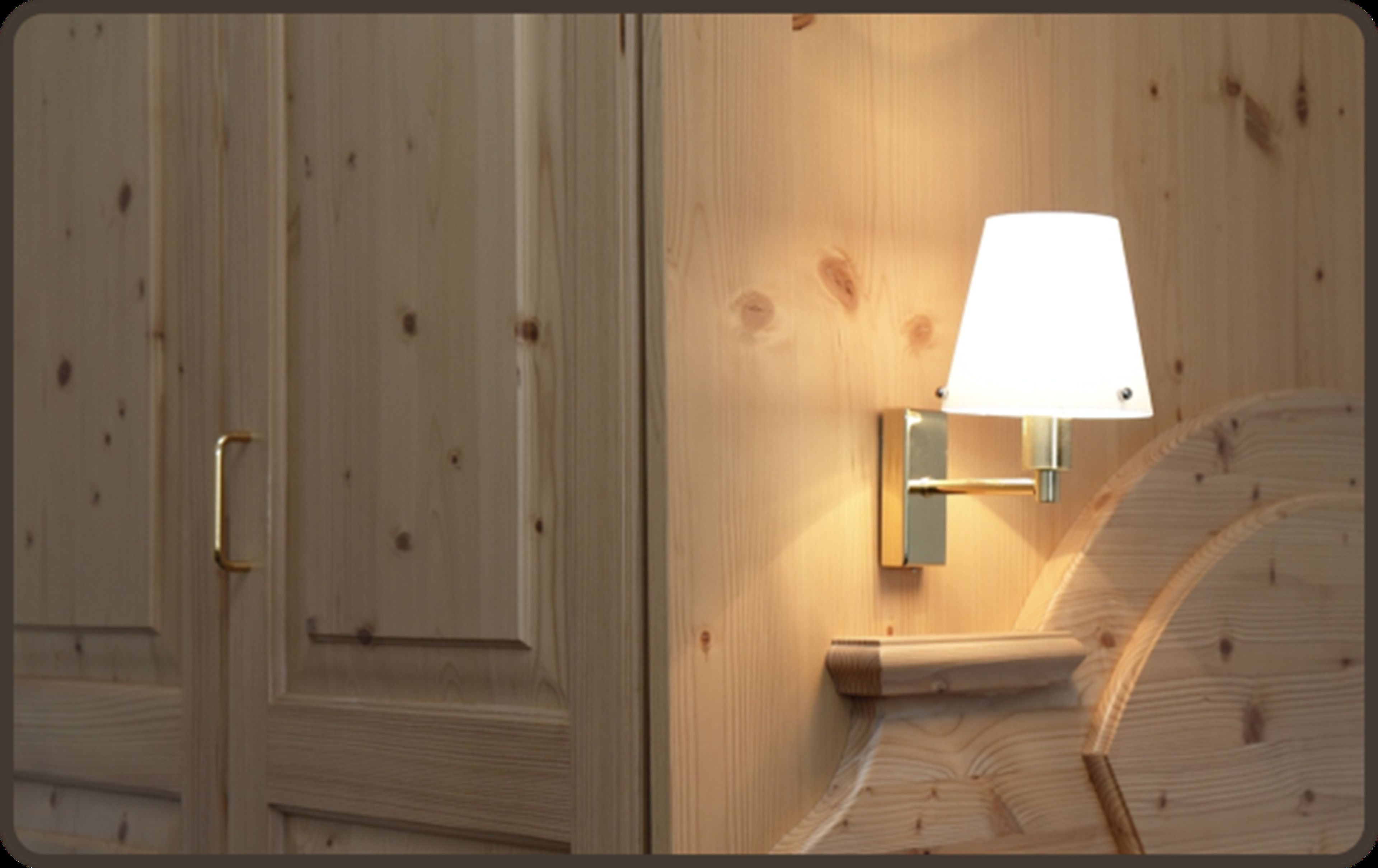 Eine Holzwand mit einer Wandleuchte und einer Tür.