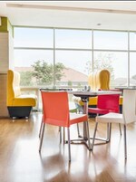 A dining area with a table and chairs, large windows, and a view of buildings outside.