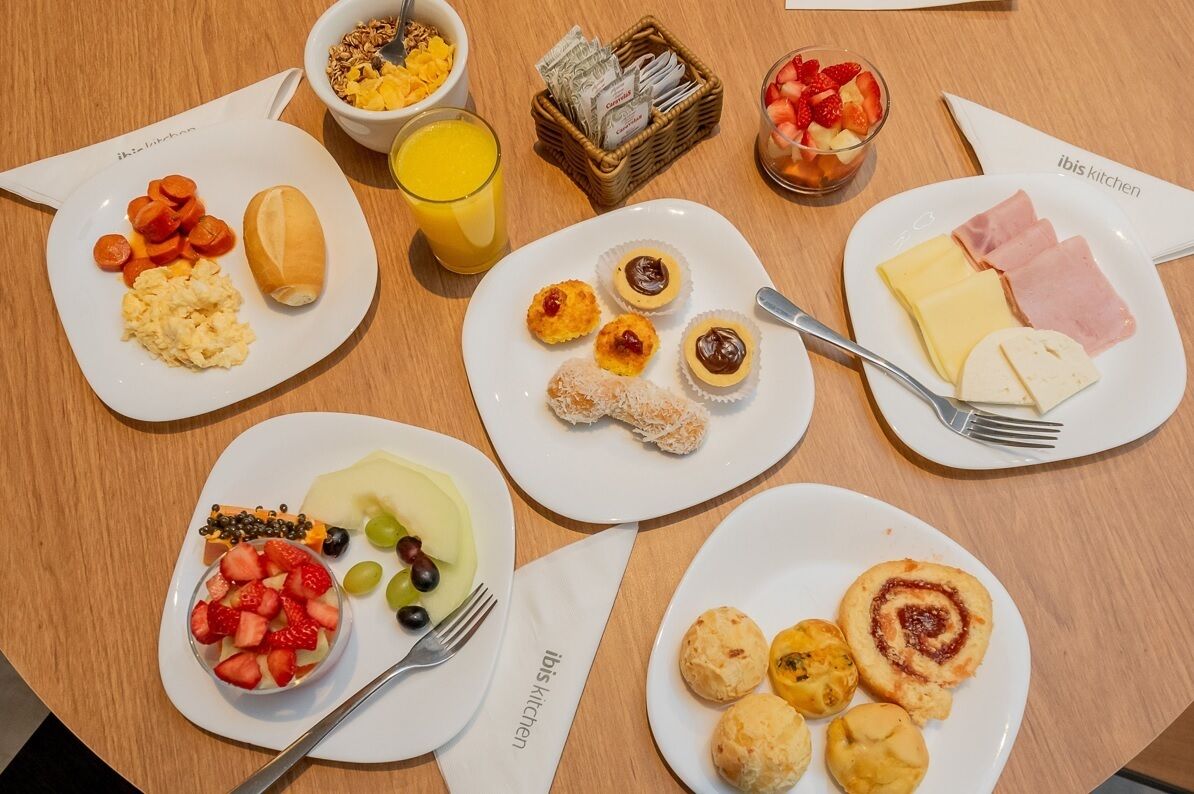 Buffet de l'esmorzar amb diferents plats, com ara ous remenats, fruita, pastissos i formatge.