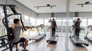 A gym with treadmills, weight machines, and a large mirror. - ibis Vitoria Aeroporto (Serra)
