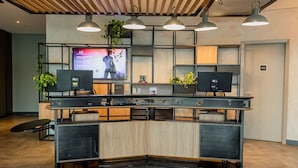 Un mostrador de recepción con una pantalla de televisión, dos monitores y una encimera de madera.