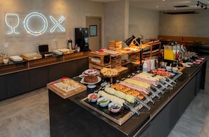 Un bufé con diversas opciones de comida y un letrero de neón que dice "ROX".