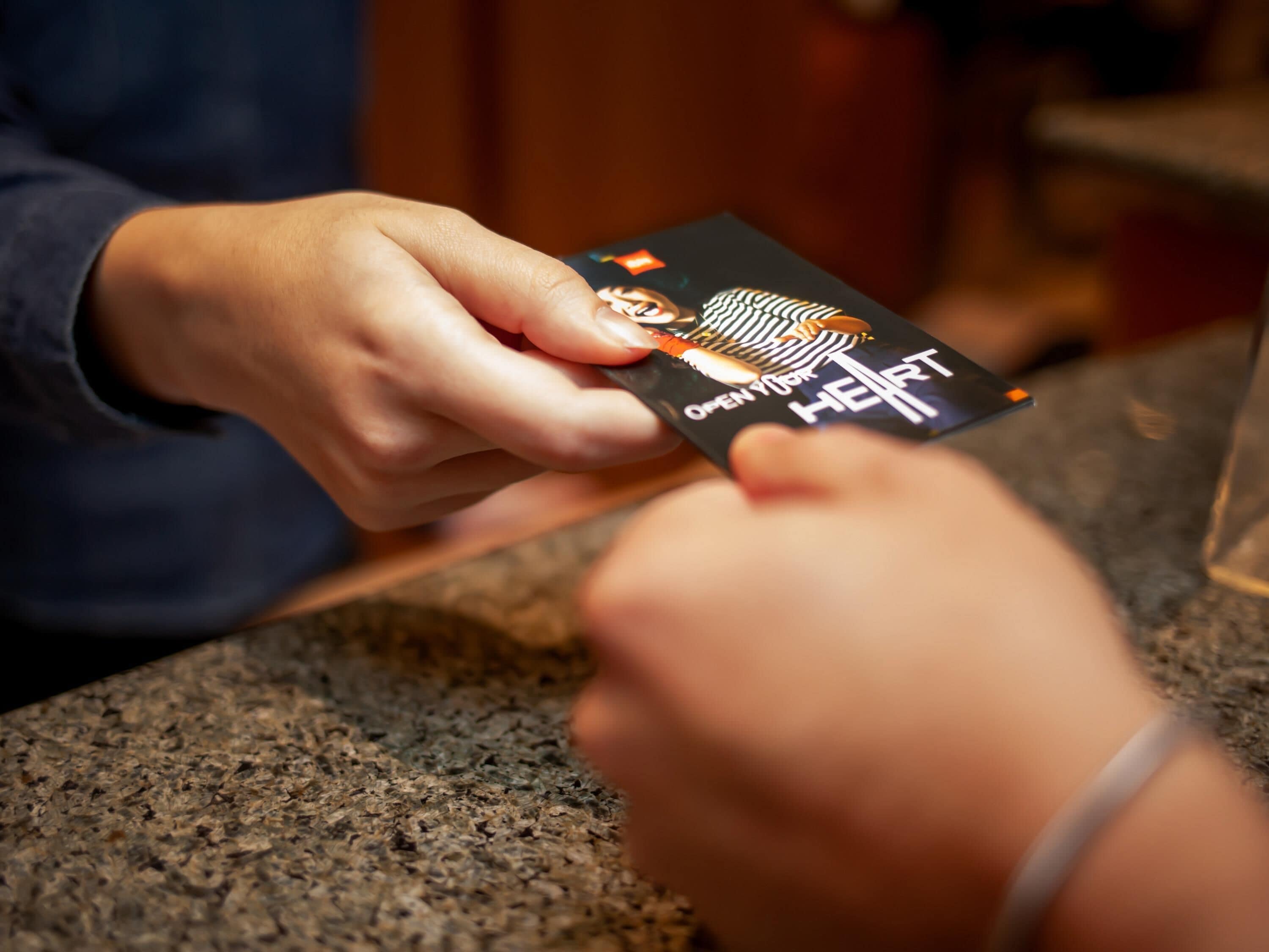 A person holding a card with a heart and text.