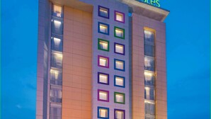 Un edificio con un letrero que dice "ibis Styles" y varias ventanas con marcos de colores.