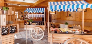 A wooden cabin-style restaurant with a buffet setup, featuring a variety of food items and a rustic interior. - Gästehaus Becher (Donzdorf)