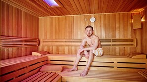 A sauna with wooden benches and a clock on the wall.