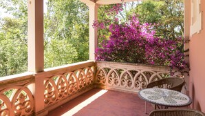 A covered patio with a wooden ceiling, a decorative railing, and a table with chairs. - Vila Duparchy (Mealhada)