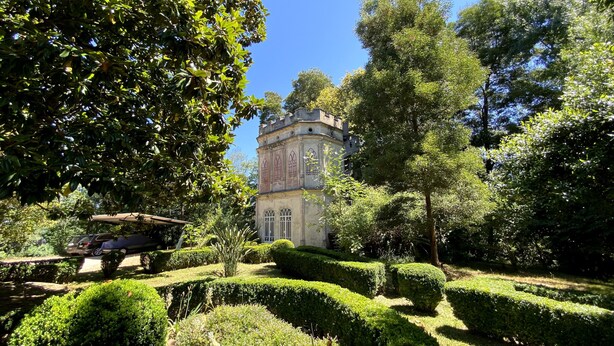 A historic tower with arched windows, surrounded by well-manicured hedges and trees. - Vila Duparchy (Mealhada)