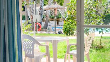 Relax in a tranquil backyard oasis with a pool, lounge chairs, and lush greenery.