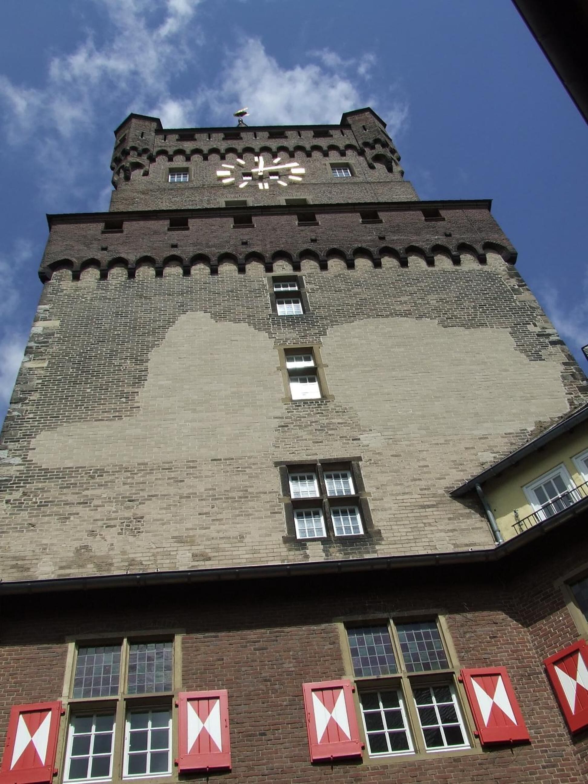 Un grand immeuble surmonté d’une horloge, doté de nombreuses fenêtres et présentant un style architectural particulier.