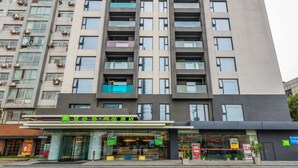 Un hôtel à plusieurs étages doté de balcons, d’un restaurant situé au rez-de-chaussée et d’une signalétique dans une langue étrangère.