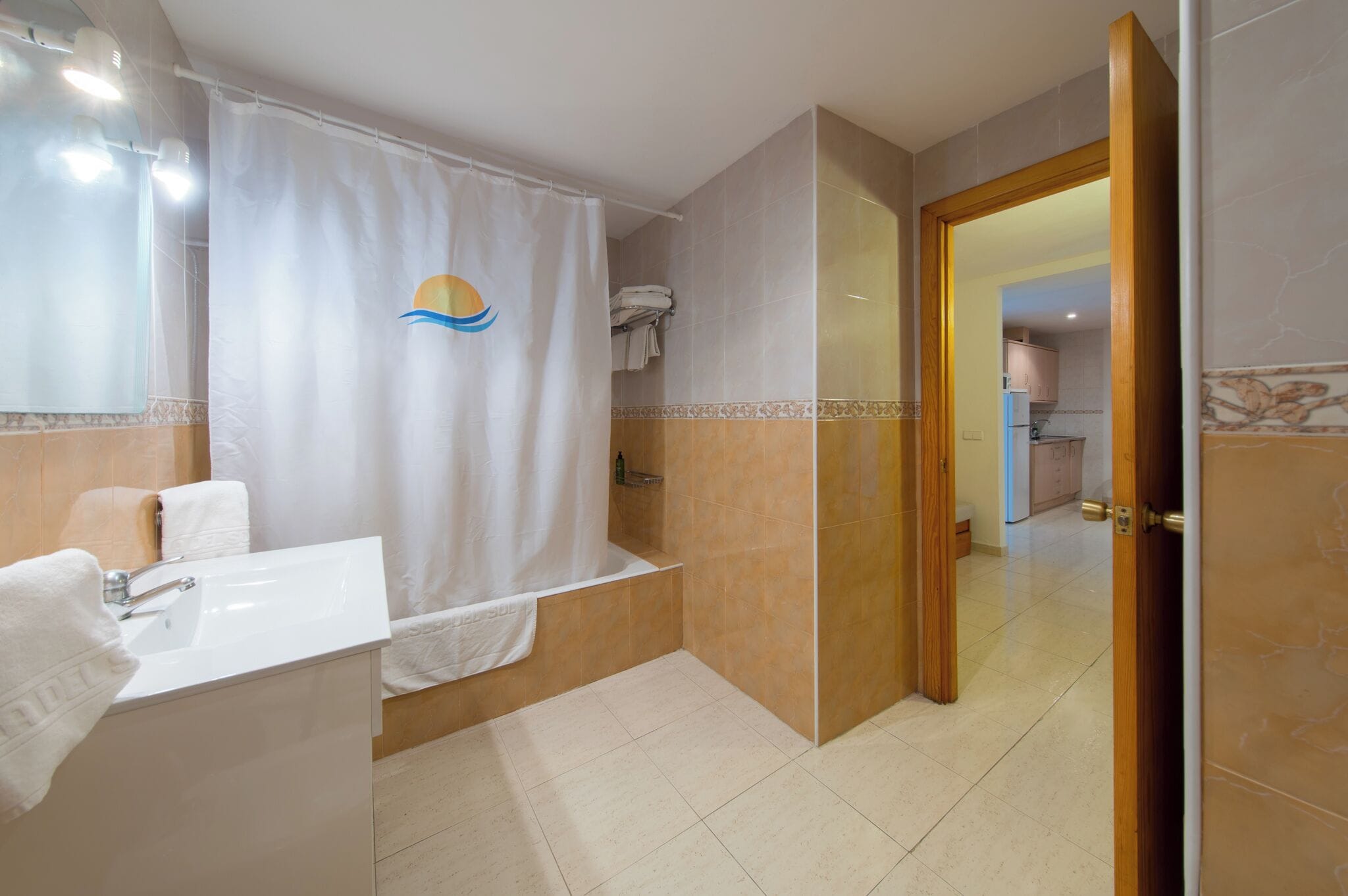 A modern bathroom with a bathtub, a sink, and a shower curtain with a sun design.