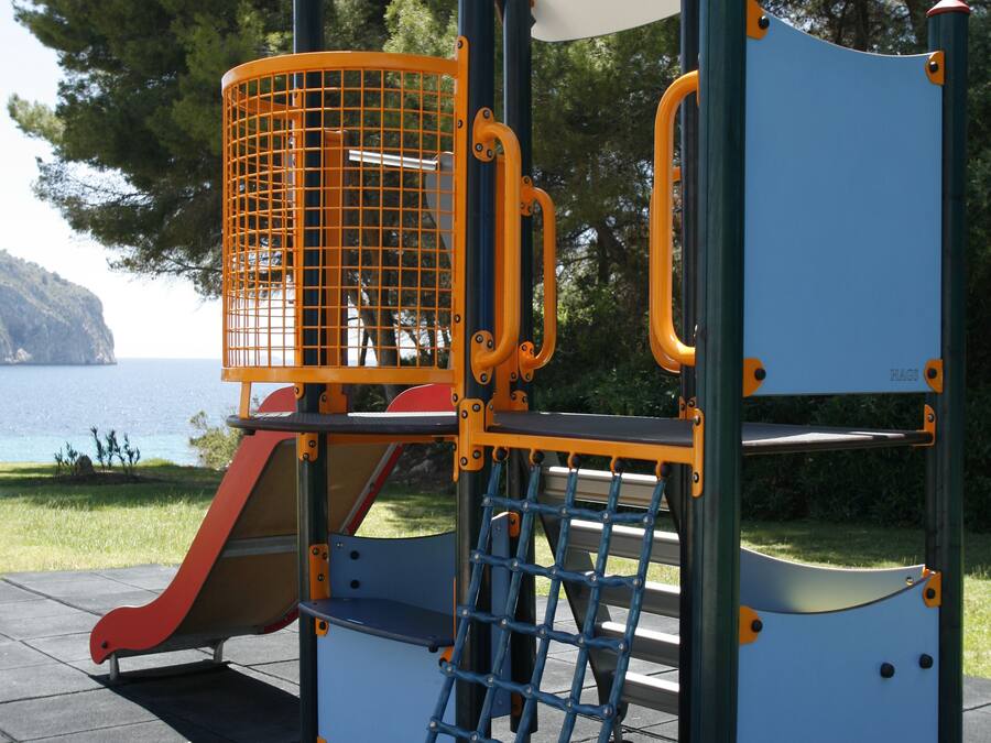 Estructura de juegos infantiles con tobogán, red de escalada y escalones.