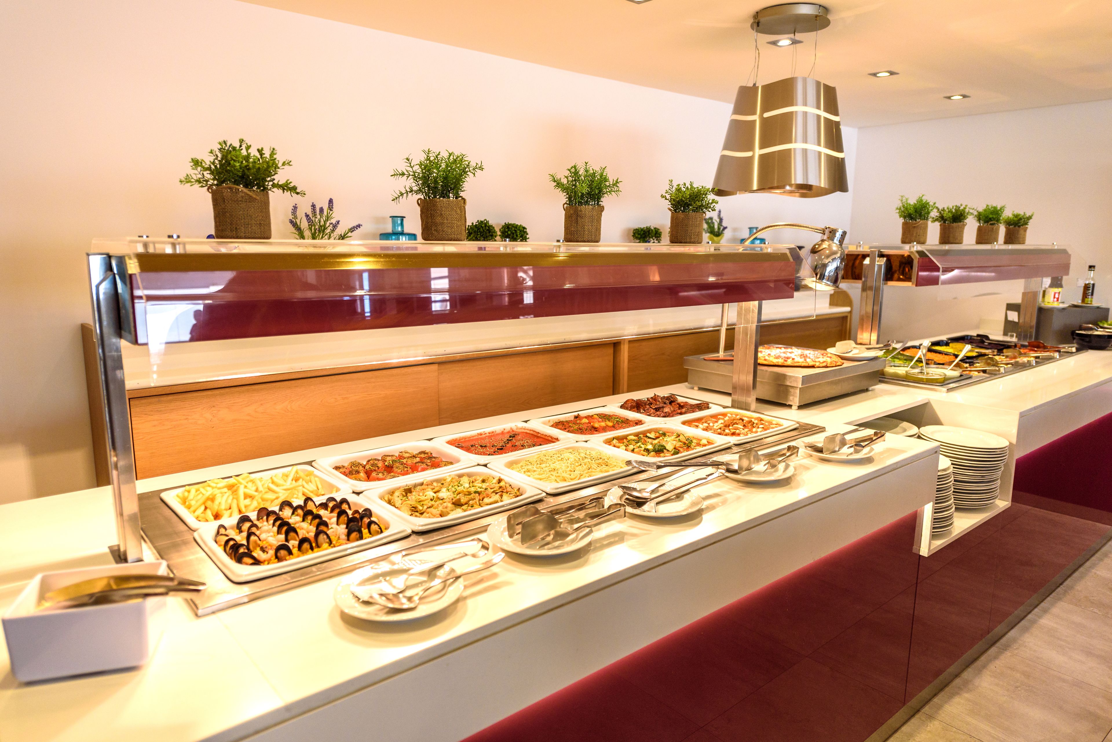 Un buffet proposant une variété de plats et agrémenté d’une composition florale décorative.
