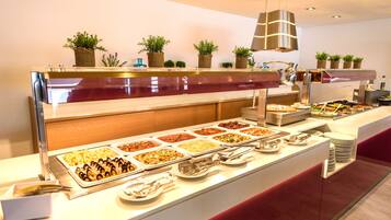Un bufé con diversas opciones de comida y una decoración floral.