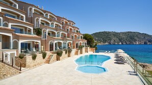 Un hôtel à plusieurs étages doté d’une piscine et offrant une vue sur la mer.