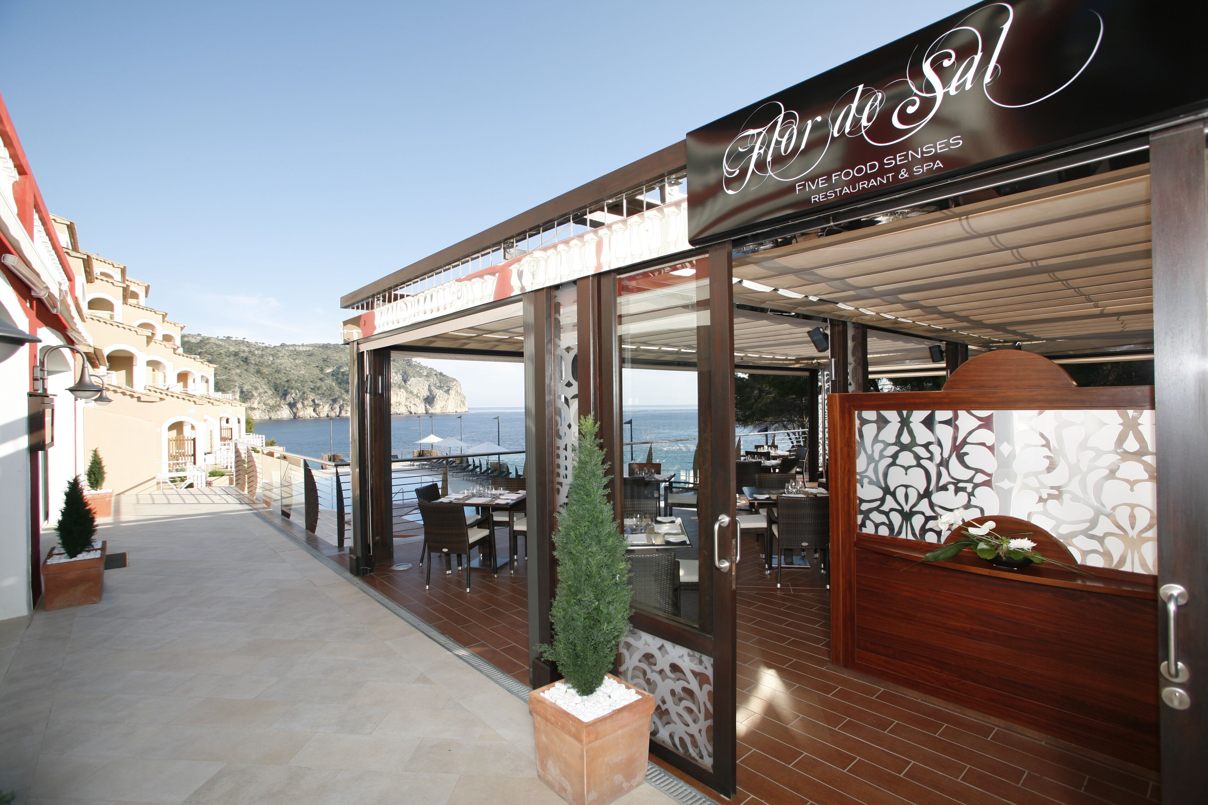 Ein Restaurant mit Meerblick, Außenbereich und einer Holzfassade.