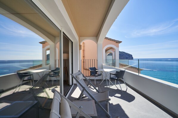 Un balcon avec vue sur la mer, comprenant une table et des chaises.