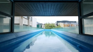 An indoor swimming pool with a clear view of the surrounding buildings. - Quest Parnell (Auckland)