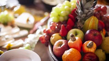 A fruit bowl with various fruits including apples, oranges, and grapes.