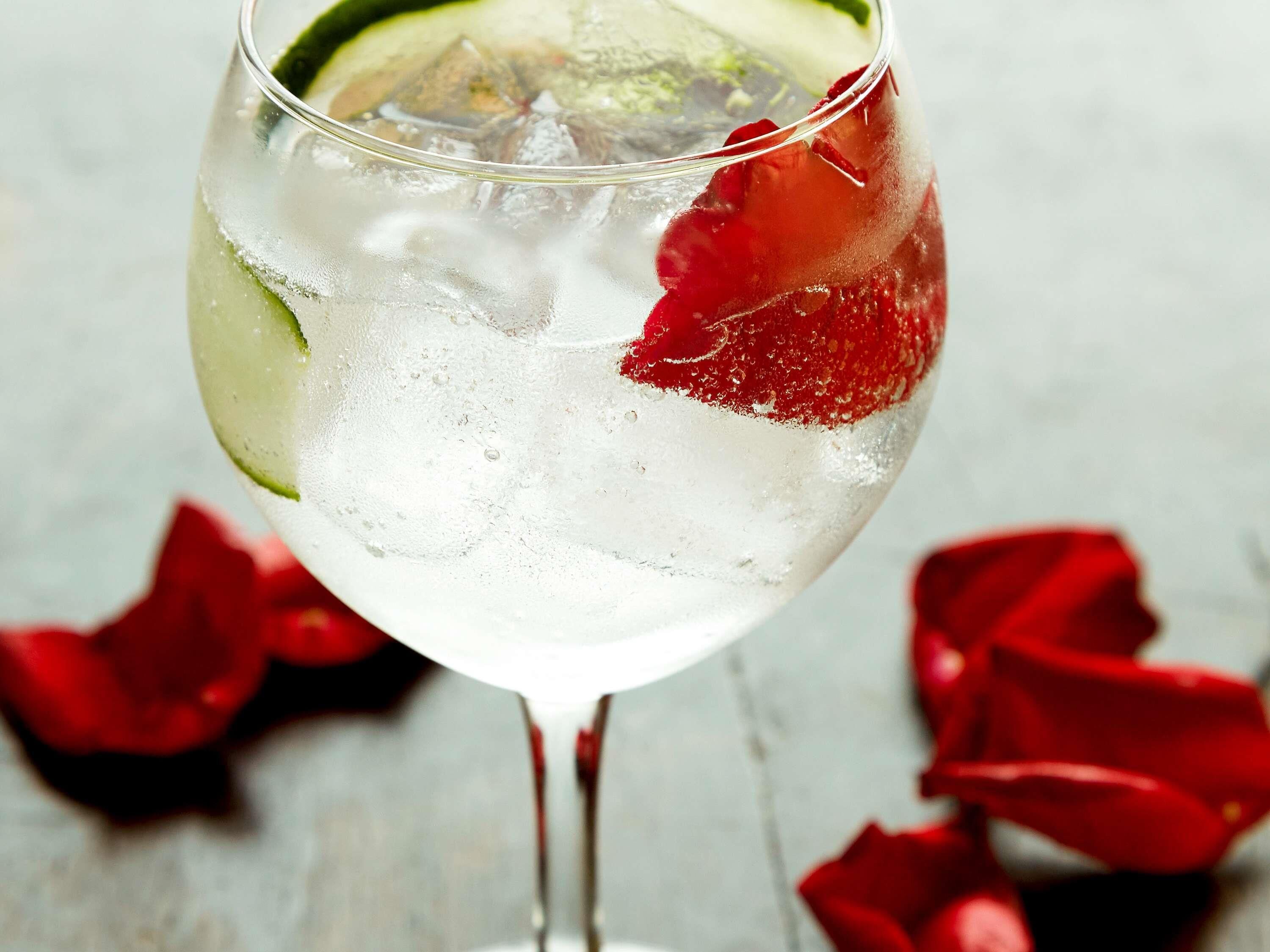 Un vaso con cubitos de hielo, una rodaja de lima y una fresa.