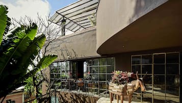 A modern building with a glass facade, a staircase, and a wooden horse sculpture.