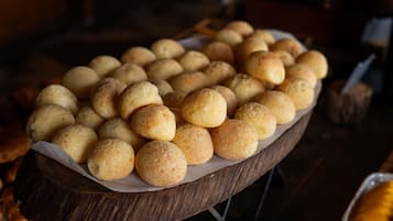 Uma tábua de madeira com uma seleção de doces redondos e dourados.