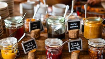 A variety of food items in jars with labels, arranged on a wooden surface.