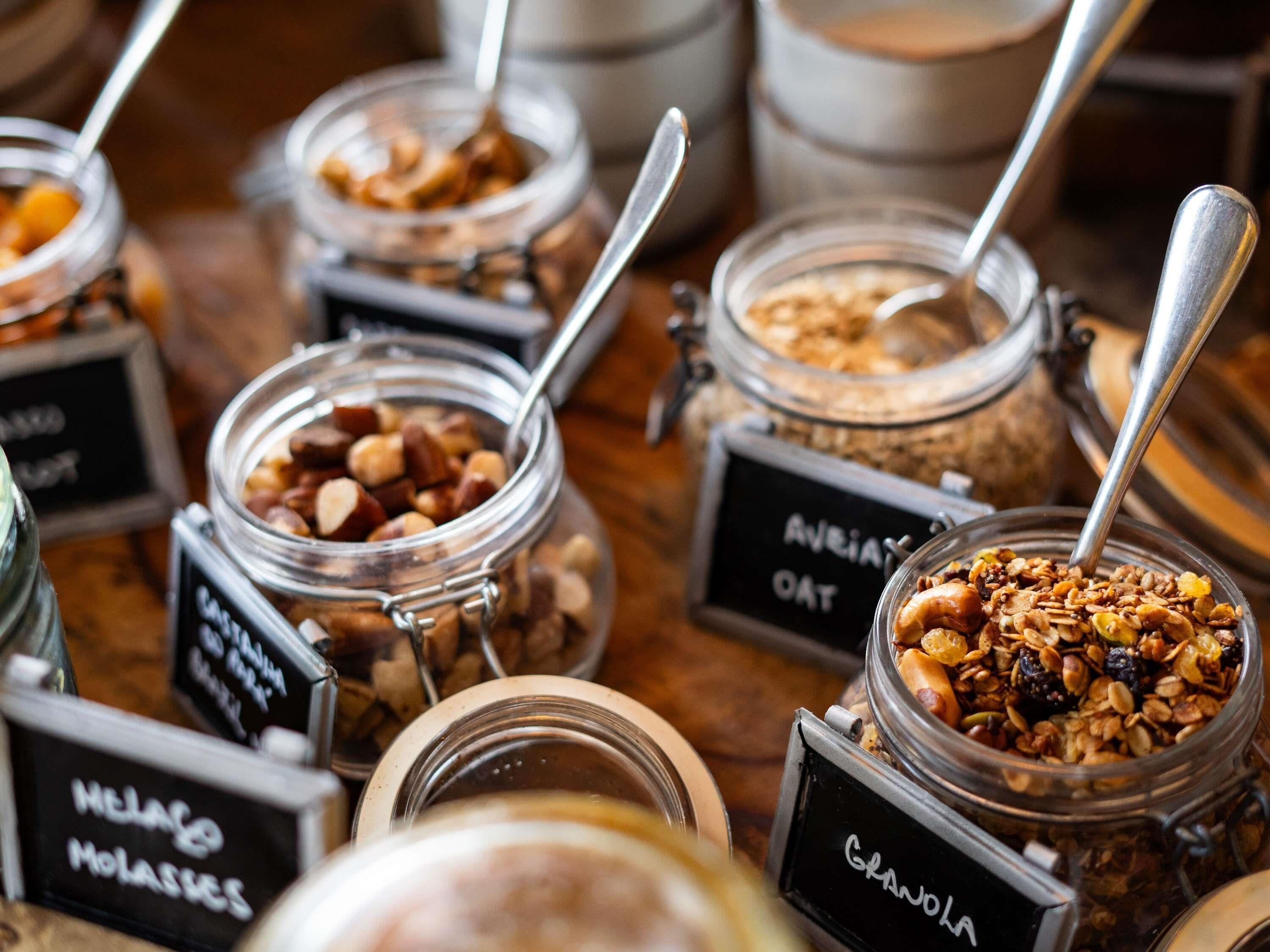 Flera glasburkar med metallock, var och en försedd med en etikett som anger innehållet, till exempel ”HAVRE”, ”NÖTTER” och ”MÜSLI”.