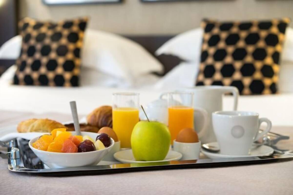 Een ontbijfwagen met fruit, eieren, sap en een croissant.