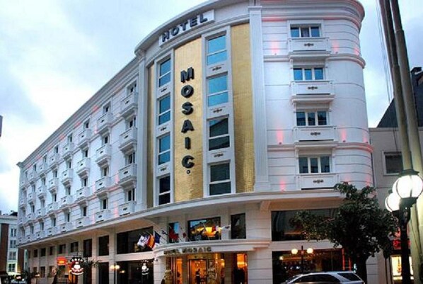 A hotel with a prominent "MOSAIC" sign, multiple floors, and a classic architectural style.
