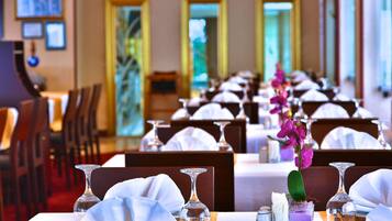 Un restaurante con mesas dispuestas para comer, destacando copas transparentes y manteles blancos.