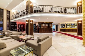 A hotel lobby with a reception desk, seating area, and a staircase. - Hotel Mosaic (Istanbul)