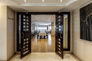 A hotel lobby with a long reception desk, a clock on the wall, and a large abstract art piece. - Hotel Mosaic (Istanbul)