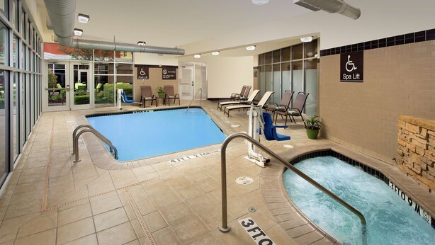 A hotel pool area with two pools, a spa lift, and a wheelchair-accessible sign. - Hilton Garden Inn San Antonio Airport South (San Antonio)
