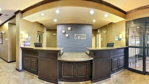 A reception area with a curved counter, a reception desk, and a wall-mounted sign. - Holiday Inn Express Hotel & Suites Clovis by IHG (Clovis)