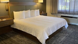 Una cama bien hecha con sábanas blancas, un cabecero de madera y dos lámparas de noche.